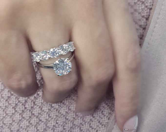 This wedding ring set features a 2.50 CT Round Cut IGI Certified CVD Lab Grown Diamond in a cathedral setting and 1 carat five stone 14K white gold diamond wedding  band