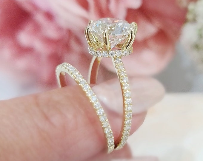 This stunning 14Kt yellow gold diamond solitaire engagement ring with hidden halo and pave diamonds on the band features a 3 carat IGI certified Ideal round brilliant cut CVD lab grown diamond and 0.33 carats accent diamonds accomopanied by a 0.22 carats matching wedding band