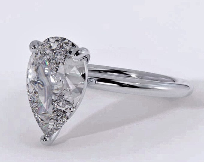 This classic dainty 14K white gold solitaire setting features a 2 carat pear cut IGI certified CVD lab grown diamond