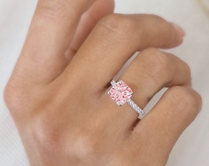 This classic solitaire pave set diamond ring features a 1.5 carat IGI certified CVD lab grown pink cushion cut diamond