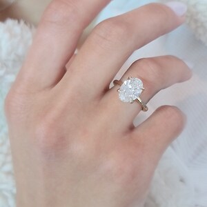 May include: A gold ring with a large oval-shaped diamond.