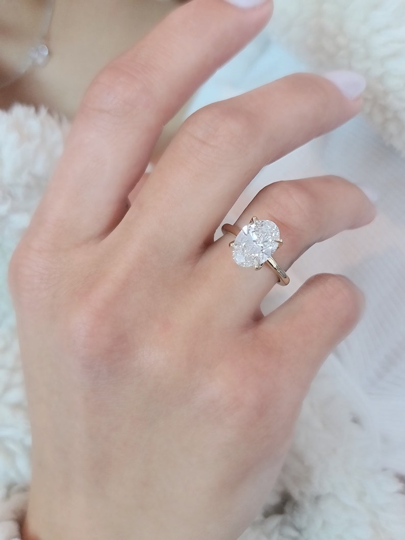 May include: A gold ring with a large oval-shaped diamond.