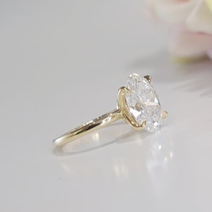 May include: A gold engagement ring with a large oval-shaped diamond.