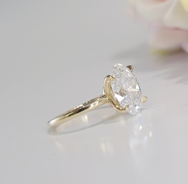 May include: A gold engagement ring with a large oval-shaped diamond.