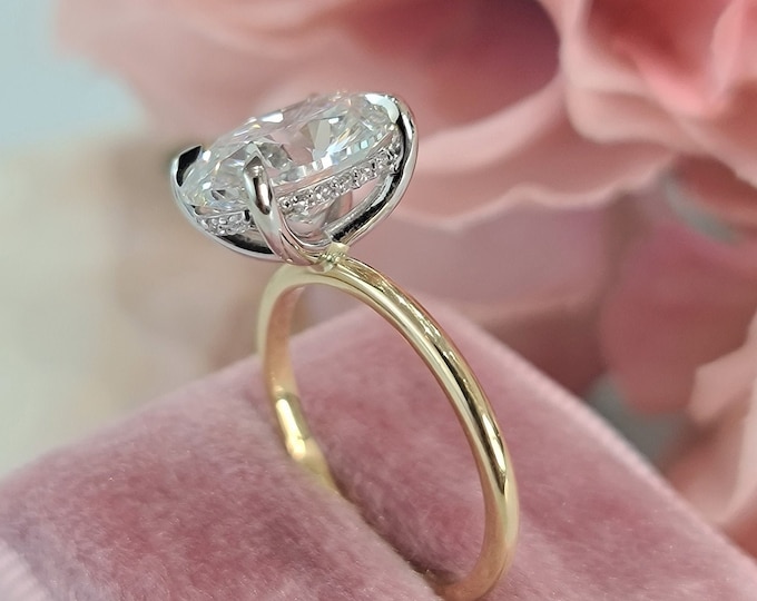 This 2 tone 14K gold dainty hidden halo setting features a 3 carat oval cut IGI certified CVD lab grown diamond
