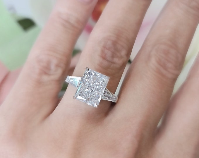 This Unique Timeless Three Stone Ring features a 3 Carat Radiant Cut IGI Certified CVD lab grown diamond accentuated with 0.50ct tapered baguette side stones