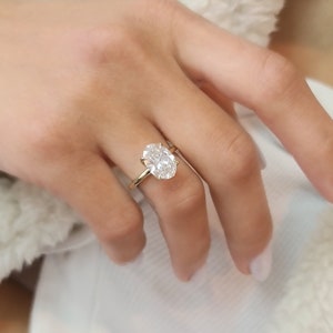 May include: A gold ring with a large oval-shaped diamond.