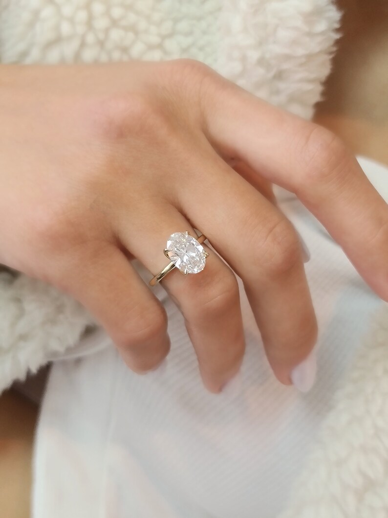 May include: A gold ring with a large oval-shaped diamond.