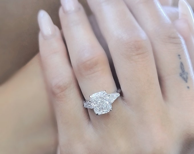 This Unique Three Stone Engagement Ring features a  3 Carat IGI Certified CVD lab grown elongated Cushion Cut accentuated  with 0.40 carats shield cut side stones