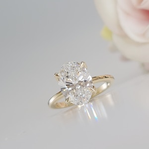 May include: A gold engagement ring with a large oval-shaped diamond.