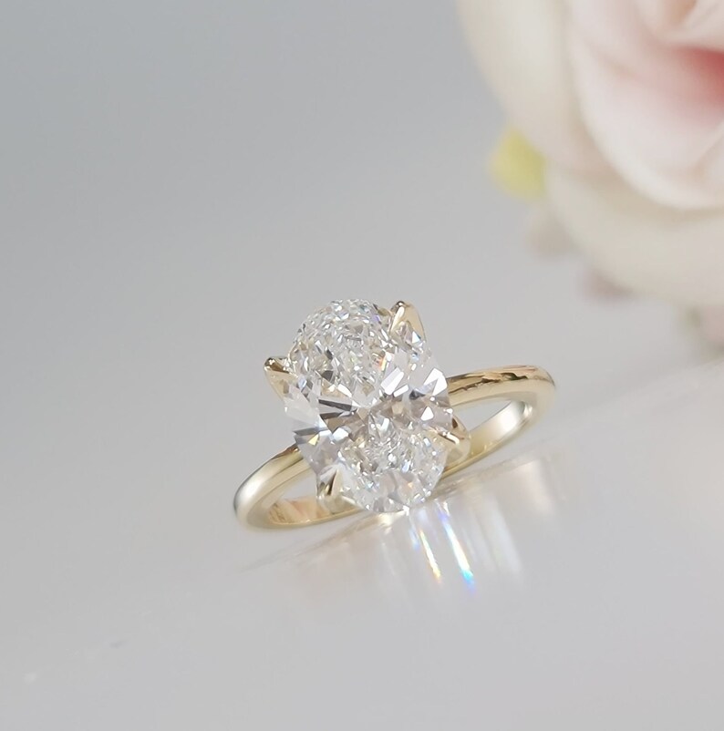 May include: A gold engagement ring with a large oval-shaped diamond.