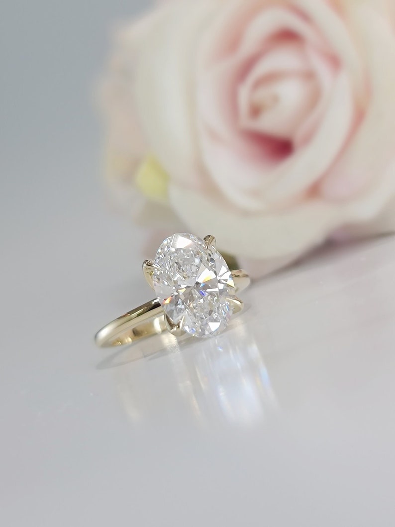 May include: A gold engagement ring with a large oval-shaped diamond.
