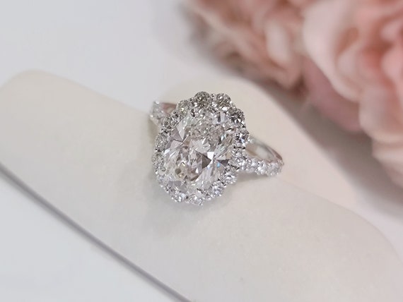 Oval engagement ring with halo and shop side stones