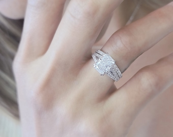 This elegant  14k gold split shank diamond setting features a 2 carat elongated radiant cut IGI certified CVD lab grown diamond accompanied by a matching wedding band