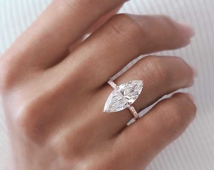 This Unique hidden halo Engagement Ring features a  4 Carat IGI Certified CVD lab grown Marquise Cut diamond accentuated  with 0.57 carats  side diamonds
