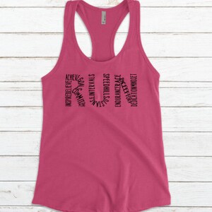 May include: Pink racerback tank top with black text that reads "RUN" and is made up of words related to running, such as "speed", "endurance", "dedication", and "believe".