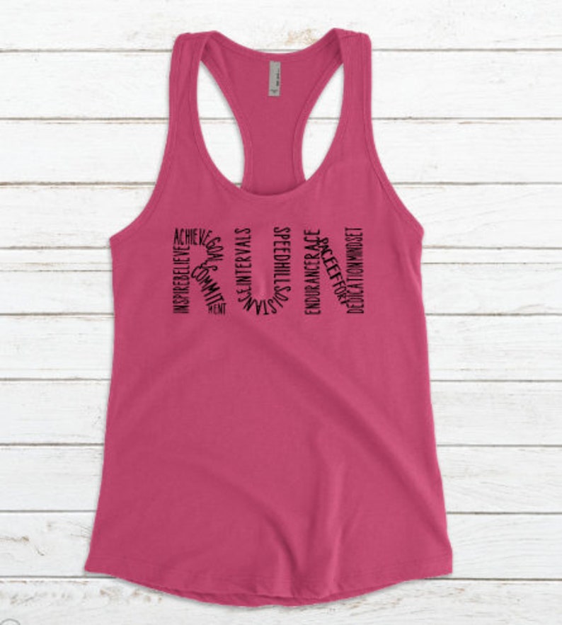 May include: Pink racerback tank top with black text that reads "RUN" and is made up of words related to running, such as "speed", "endurance", "dedication", and "believe".