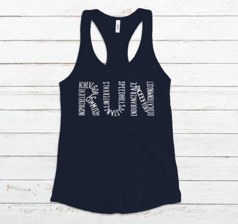 May include: A navy blue tank top with the word "RUN" spelled out in white text. The letters are made up of words related to running, such as "inspire", "believe", "achieve", "community", "goals", "intervals", "strength", "speed", "hills", "race", "endurance", "pace", "effort", "dedication", "mindset".