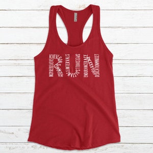 May include: Red racerback tank top with white text that reads "RUN" with words surrounding the letters, including "achieve", "inspire", "believe", "commit", "goals", "speed", "intervals", "strength", "endurance", "race", "effort", "dedication", and "mindset".