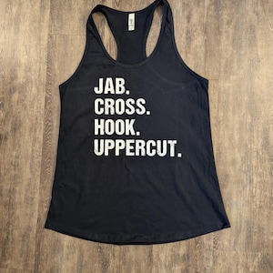 May include: Black tank top with white text that reads "JAB. CROSS. HOOK. UPPERCUT."
