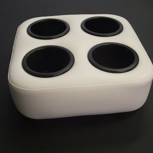 May include: White padded cup holder with four black cup holders.