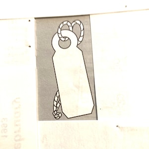May include: A white tag with a rope loop at the top. The tag is blank and has a slightly rounded bottom.