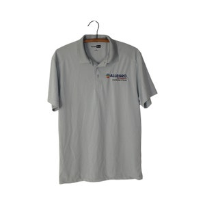 May include: A light grey polo shirt with a short sleeve and a logo on the left chest that says "ALLEGRO MICROSYSTEMS PHOTONICS TEAM".