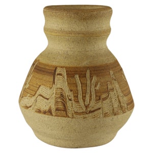 May include: A small, tan ceramic vase with a brown, carved design of mountains and cacti.