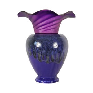 May include: A purple ceramic vase with a wide, ruffled opening and a blue and black glaze. The vase has a unique, swirling design.