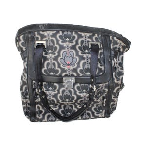 May include: A black and gray floral patterned tote bag with black leather accents and a silver clasp.
