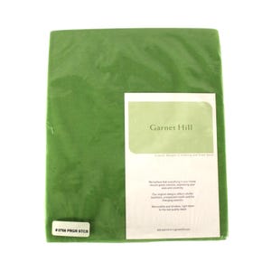 May include: A green fabric swatch with a white label that reads "Garnet Hill" and includes the text "Original designs in clothing and home decor. We believe that everything in your home should speak volumes, expressing your style and creativity. Our original designs reflect colorful traditions, unexpected motifs and the changing seasons. Memorable and timeless, right down to the last quality detail."