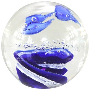 Puede incluir: Un pisapapeles de cristal transparente con diseños en espiral azules y blancos y formas azules con forma de pez. El pisapapeles tiene pequeñas burbujas de aire, lo que aumenta su atractivo decorativo. Un accesorio de escritorio único.