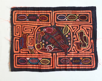 May include: A colorful mola textile with a black background and orange border. The mola features a geometric design with two birds and leaves embroidered in various colors.