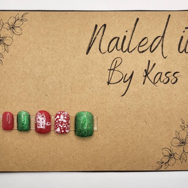 Short red and green glitter Christmas nails with gift and bows decorations as gel press on nails made in custom size or shape.