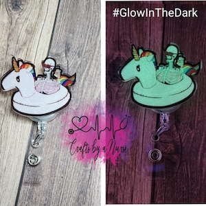 May include: A white and rainbow unicorn inflatable pool float with a skeleton wearing sunglasses and a hat riding on it. The float is attached to a clear retractable badge reel with a silver clip. The text #GlowInTheDark is visible in the image.