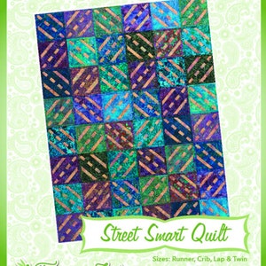 May include: A quilt pattern called "Street Smart Quilt" with a colourful geometric design. The quilt is made up of squares with diagonal lines in a variety of blue, green, and purple shades. The pattern is from Fairy Lake Quilt Designs, a company that specialises in "Fun & Done! Quilting".