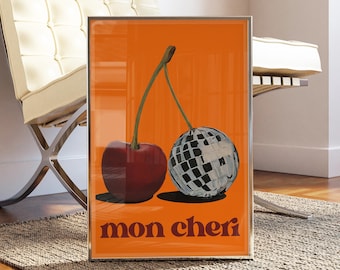 Peut inclure: Une impression encadrée avec un fond orange représentant deux cerises. Une cerise est rouge et l'autre est une boule disco. Le texte "mon cheri" est imprimé en orange en bas de l'impression.