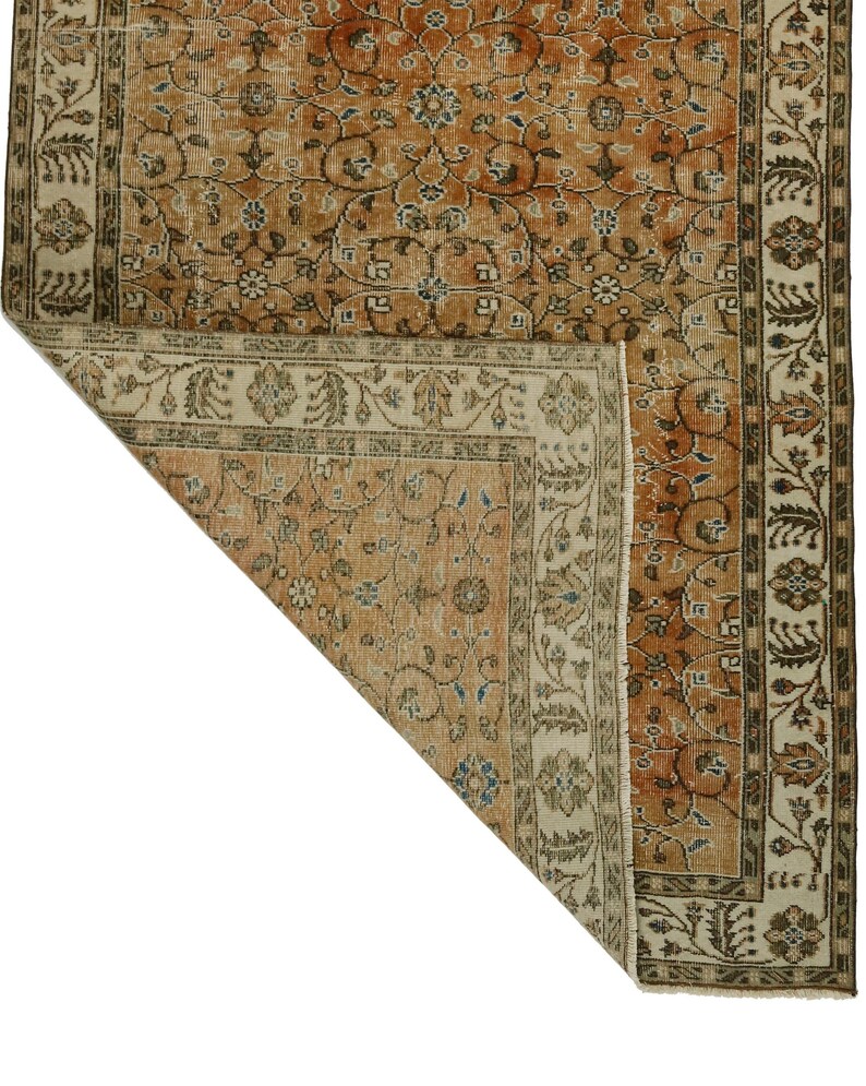 May include: A vintage rug with a floral pattern in shades of brown, beige, and cream. The rug has a border with a repeating design.