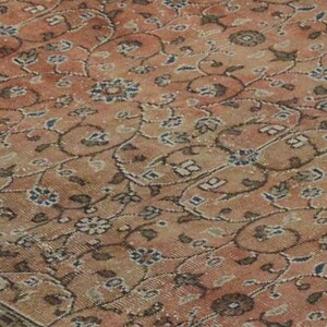 May include: A vintage rug with a floral pattern in shades of pink, brown, and white.