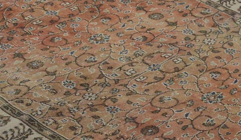 May include: A vintage rug with a floral pattern in shades of pink, brown, and white.