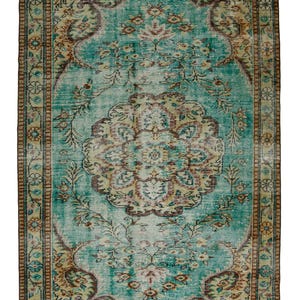 May include: Rectangular turquoise rug with a distressed, vintage look. The rug features a central medallion design in beige, brown, and teal, surrounded by floral and vine patterns. The border is a darker brown with intricate detailing, creating a classic, aged aesthetic.