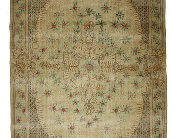 May include: A vintage rug with a floral pattern in shades of pink, green, and brown. The rug has a central medallion with a geometric design and a border with a repeating pattern.