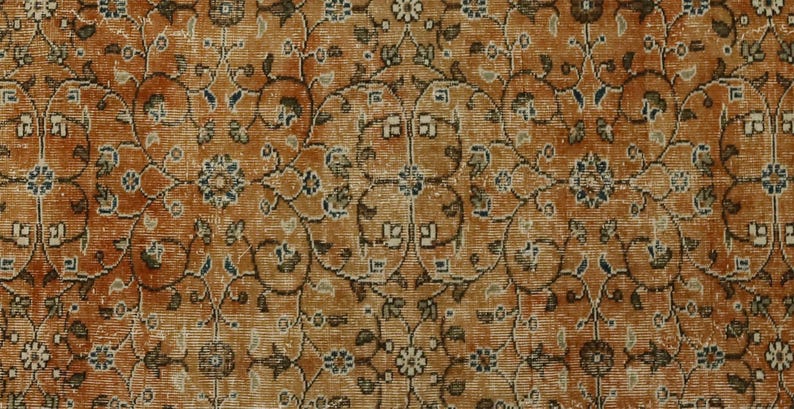May include: A vintage rug with a detailed floral pattern in shades of brown, beige, and blue. The rug has a worn, distressed look, giving it a unique character.