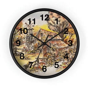 Könnte beinhalten: Eine Wanduhr mit schwarzem Rahmen und einem Aquarellbild eines Bauernhauses mit Windmühle in ländlicher Umgebung. Das Zifferblatt der Uhr hat schwarze römische Ziffern als Stundenmarkierungen und schwarze Zeiger.