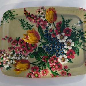 Peut inclure: Plateau rectangulaire avec un motif floral. Le plateau présente un fond crème et est orné d'un bouquet de fleurs aux tons de rouge, blanc, jaune et bleu. Le plateau mesure environ 30 cm sur 46 cm.