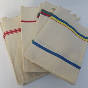 Puede incluir: Conjunto de cinco toallas de t&eacute; de algod&oacute;n blanco con rayas de colores. Las toallas tienen rayas rojas, azules, amarillas y verdes.