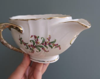 ピンクペッパーコーンのモチーフがあしらわれた磁器製のグレイビーボート