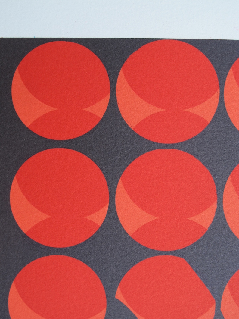 Pode incluir: Um fundo preto com nove c&iacute;rculos vermelhos, cada um com uma forma de crescente vermelho ligeiramente mais claro no centro.