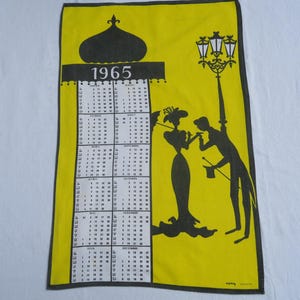 Op de afbeelding: Een vintage kalenderhanddoek uit 1965 met een gele achtergrond en een zwarte rand. De handdoek heeft een kalenderraster, een silhouet van een stel en een straatlantaarn. De tekst "1965" staat bovenaan.