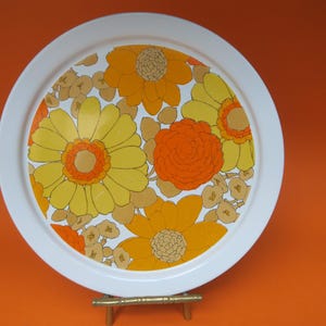 Round orange metal tray with 70s flowers